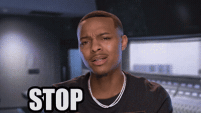 A Man Wearing A Necklace And A Black Shirt Is Saying Stop GIF