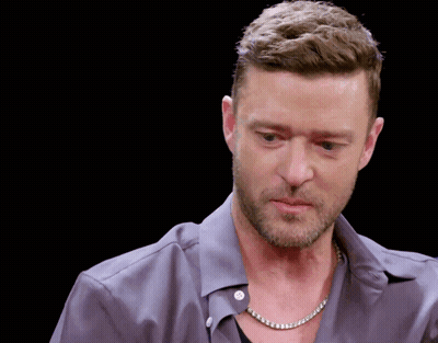 A Man Wearing A Necklace And A Grey Shirt GIF