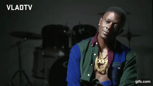 A Man Wearing A Necklace That Says Xop Is Smiling GIF