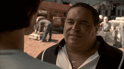 A Man Wearing A Necklace With A Cross On It GIF