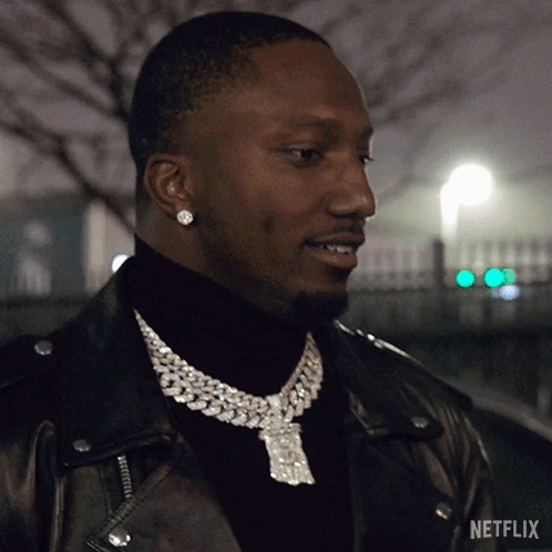 A Man Wearing A Necklace With A Netflix Logo On It GIF