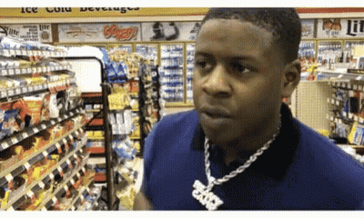 A Man Wearing A Necklace With A Pendant That Says ' Brooklyn ' On It Is In A Store GIF