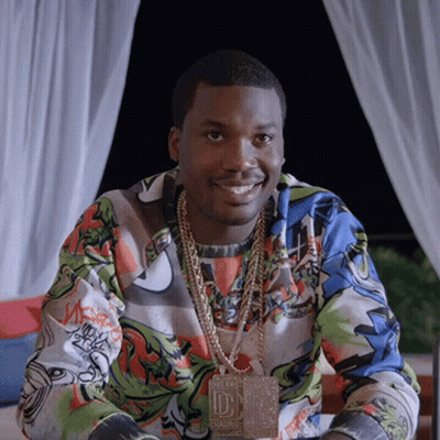 A Man Wearing A Necklace With The Letter D On It Smiles GIF
