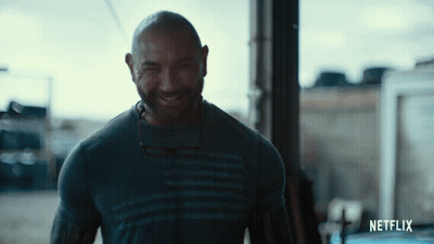 A Man Wearing A Netflix Shirt Is Smiling GIF
