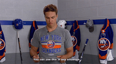A Man Wearing A New York Islanders T-Shirt Is Standing In A Locker Room GIF