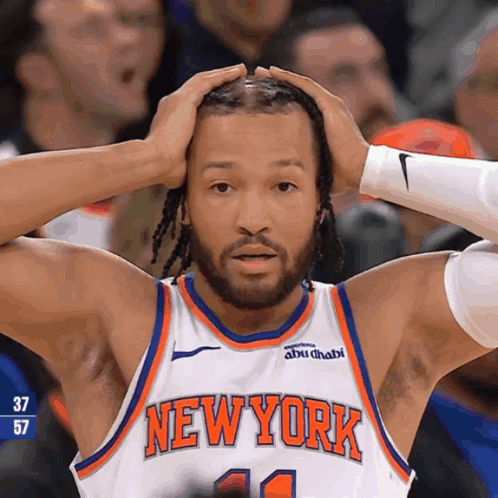 A Man Wearing A New York Jersey Holds His Head In His Hands GIF