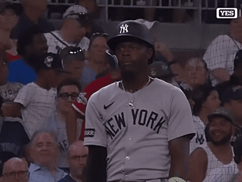 A Man Wearing A New York Jersey Holds Up His Hand GIF
