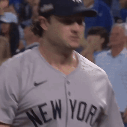 A Man Wearing A New York Jersey Is Standing In The Crowd GIF