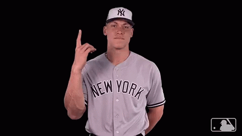 A Man Wearing A New York Jersey Points Upwards GIF