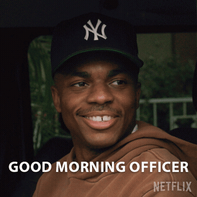 A Man Wearing A New York Yankees Hat Is Smiling And Says Good Morning Officer Netflix GIF