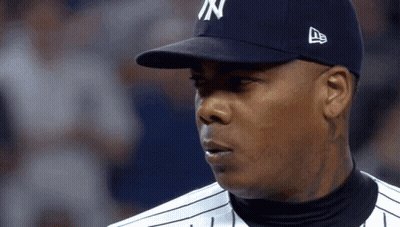 A Man Wearing A New York Yankees Hat Looks At Something GIF