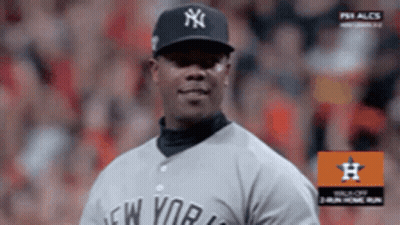 A Man Wearing A New York Yankees Jersey Stands On A Baseball Field GIF