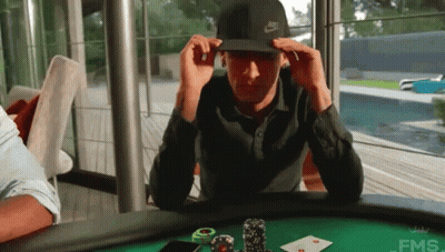 A Man Wearing A Nike Hat Is Sitting At A Poker Table GIF