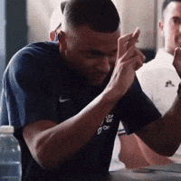 A Man Wearing A Nike Shirt Is Holding His Hands Together GIF