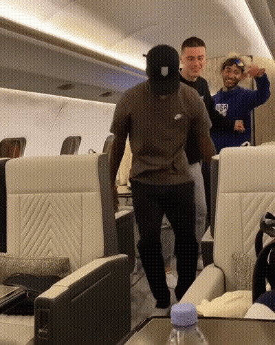 A Man Wearing A Nike T-Shirt Is Dancing On A Plane GIF