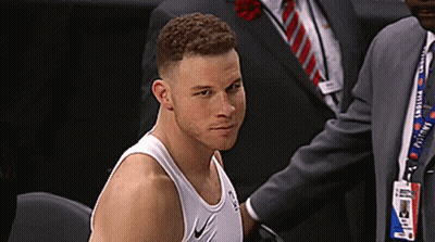A Man Wearing A Nike Tank Top Is Sitting In A Chair GIF