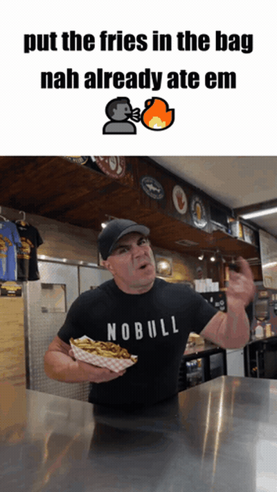 A Man Wearing A Nobull Shirt Is Holding A Tray Of French Fries GIF