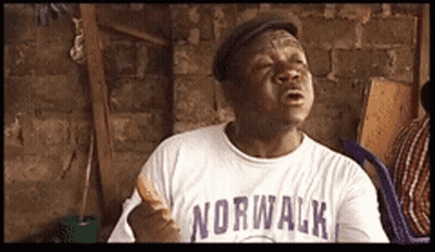 A Man Wearing A Norwalk Shirt Holds A Sandwich GIF