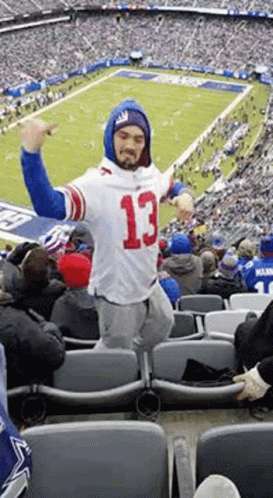 A Man Wearing A Number 13 Jersey Is Standing In A Stadium . GIF
