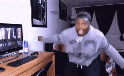 A Man Wearing A Number 35 Sweatshirt Is Standing In Front Of A Computer Monitor GIF