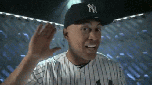 A Man Wearing A Ny Hat And A Striped Shirt GIF