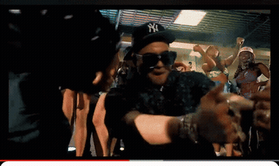 A Man Wearing A Ny Hat And Sunglasses Is Dancing In A Crowd GIF