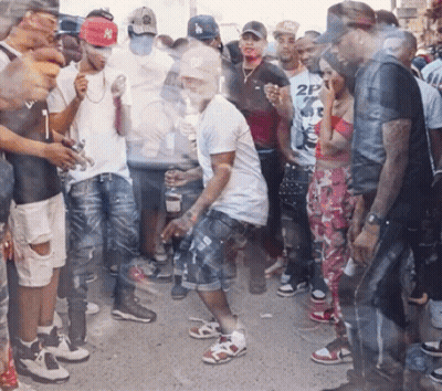 A Man Wearing A Ny Hat Is Dancing In A Crowd GIF