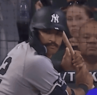 A Man Wearing A Ny Hat Is Swinging His Bat GIF