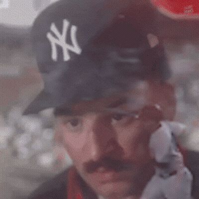 A Man Wearing A Ny Yankees Hat Looks Out A Window GIF