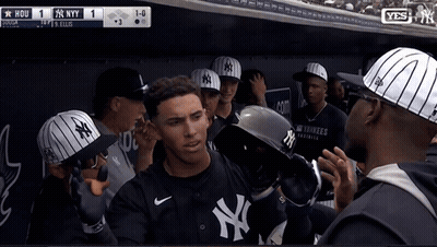 A Man Wearing A Ny Yankees Jersey Stands In A Dugout GIF