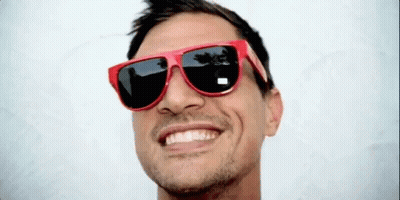 A Man Wearing A Pair Of Red Sunglasses Smiles For The Camera GIF