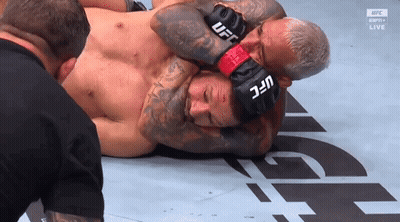 A Man Wearing A Pair Of Ufc Boxing Gloves Holds Another Man 'S Head GIF