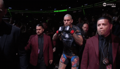 A Man Wearing A Pair Of Ufc Boxing Gloves Stands In A Crowd GIF