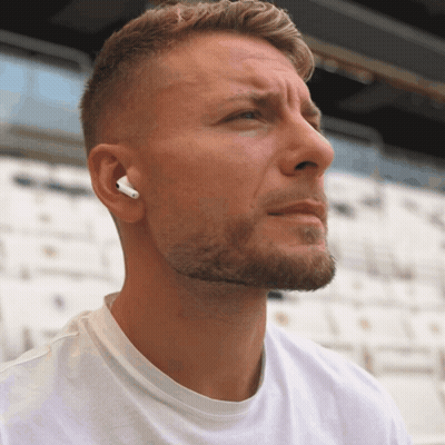 A Man Wearing A Pair Of White Ear Buds Looks To The Side GIF