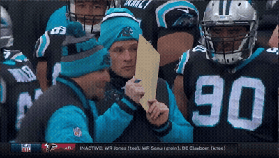 A Man Wearing A Panthers Hat Holds A Piece Of Paper GIF