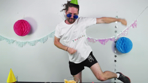 A Man Wearing A Party Hat And Sunglasses Holds A Star In His Hands GIF