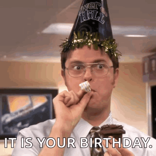 A Man Wearing A Party Hat Is Eating A Piece Of Cake With The Words It Is Your Birthday Written Below Him GIF