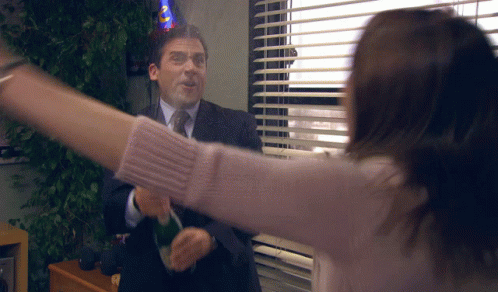 A Man Wearing A Party Hat Throws A Bottle Of Champagne At A Woman GIF