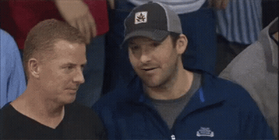 A Man Wearing A Patagonia Jacket Is Talking To Another Man In A Crowd GIF