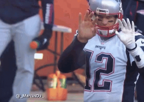 A Man Wearing A Patriots Jersey And Helmet Is Waving His Hand GIF