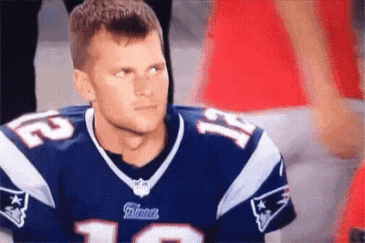 A Man Wearing A Patriots Jersey Is Sitting In The Stands . GIF