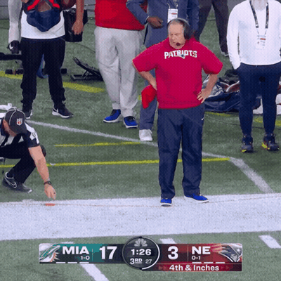 A Man Wearing A Patriots Shirt Stands On The Sidelines Of A Football Game GIF