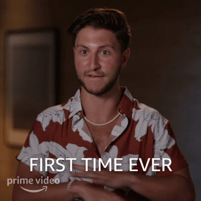 A Man Wearing A Pearl Necklace And A Shirt That Says First Time Ever GIF