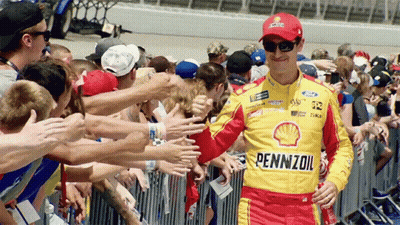 A Man Wearing A Pennzoil Shirt Is Surrounded By Fans GIF