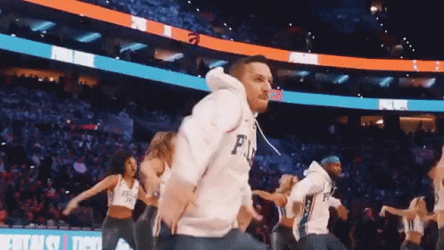 A Man Wearing A Philadelphia 76Ers Jersey Is Dancing With A Group Of Cheerleaders GIF