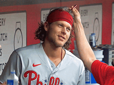 A Man Wearing A Phillies Jersey Is Getting His Hair Brushed GIF