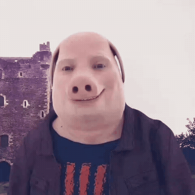 A Man Wearing A Pig Mask Is Smiling In Front Of A Building . GIF