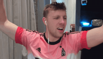 A Man Wearing A Pink Adidas Shirt With Ear Buds GIF