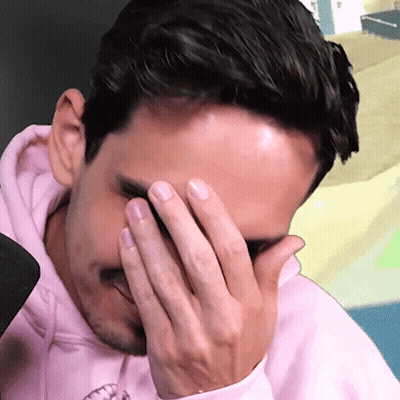 A Man Wearing A Pink Hoodie Covering His Face With His Hand GIF