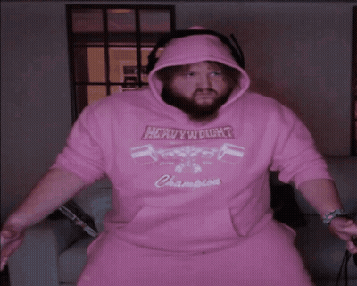 A Man Wearing A Pink Hoodie That Says Heavyweight Champions On It GIF